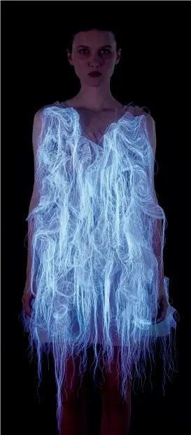  ??  ?? The (No)where (Now)here series is made of photolumin­escent thread and embedded eye-tracking technology. The dress is activated by a spectator’s gaze.