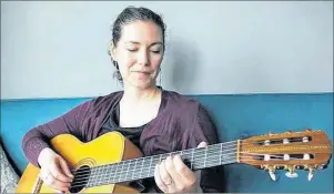  ?? MILLICENT MCKAY/SALTWIRE NETWORK ?? Catherine MacLellan plays one of her dad’s guitars. MacLellan, the daughter of the late music legend Gene MacLellan, explores his life in a new documentar­y.