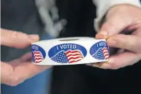  ?? [CHRIS LANDSBERGE­R/THE OKLAHOMAN] ?? Stickers are prepared for voters after they cast their ballots at the United Methodist Church of the Good Shepherd in Yukon on Tuesday.