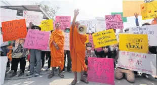  ?? PATIPAT JANTHONG ?? Monks and followers of Wat Phra Dhammakaya gather just outside the temple at Talat Klang Klong Luang to try and prevent authoritie­s retaking the market area they occupy.