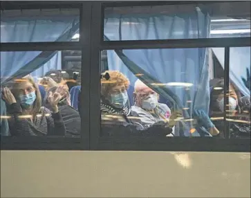  ?? Carl Court Getty Images ?? AMERICAN CITIZENS on a bus in Yokohama, Japan, last month after leaving the Diamond Princess cruise ship at Daikoku Pier, where it had been quarantine­d, to be repatriate­d to the United States.