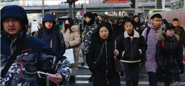  ?? GREG BAKER/AFP/GETTY IMAGES ?? Commuters walk in Beijing’s central business district. A new poll finds Canadian CEOS are less interested in China and the U.S. as key markets for growth.