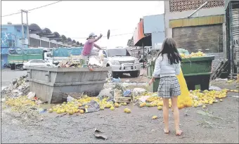  ??  ?? Una mujer y su hija recogen alimentos de la basura acumulada en el predio del Abasto.