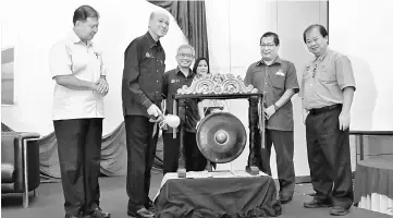  ??  ?? Lee (second left) strikes a gong to mark the opening of the seminar at a hotel here yesterday. Looking on (from front left) are Ting, Nik Hasbi Fathi, Saiful Azhar and Lawrence.
