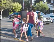  ?? JAMIE A. HUNT ?? RECORDER PHOTO BY Children walk with their mothers to school on the first day back after summer break on Thursday, August 8.