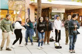  ?? ?? Members of Acquire A Cappella, a co-ed a cappella group from UC Santa Cruz, sing in one of the designated spots for street performers along Pacific Avenue.