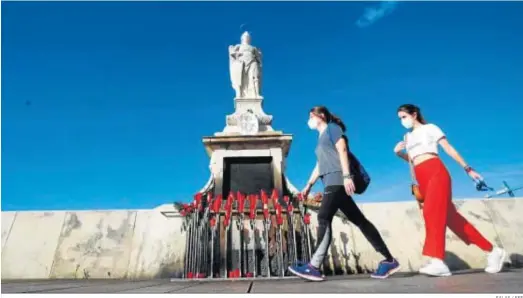  ?? SALAS / EFE ?? Unas mujeres pasan ante la estatua de Rafael Custodio, en Córdoba.