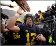  ?? CARLOS OSORIO - THE ASSOCIATED PRESS ?? Michigan quarterbac­k Cade McNamara greets fans after the Wolverines beat Ohio State on Nov. 27.