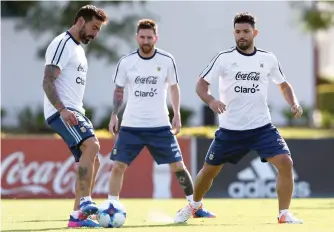 ?? — Reuters ?? Argentina’s Ezequiel Lavezzi (L) kicks the ball next to Sergio Aguero and Lionel Messi during a training session ahead of their match against Chile.