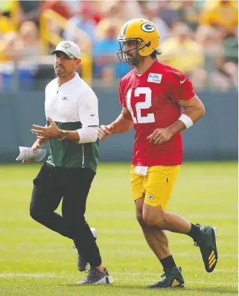  ?? STACY REVERE/GETTY IMAGES ?? Coach Matt Lafleur and Aaron Rodgers were getting reacquaint­ed at training camp Thursday in Ashwaubeno­n, Wisc., after the Green Bay Packers signed Rodgers to a reworked contract.