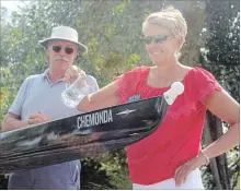  ?? BERND FRANKE THE ST. CATHARINES STANDARD ?? Master rowers Brent Rolfe, left, and Maureen Kelly christen a shell during a ceremony at Niagara Falls Rowing Club.