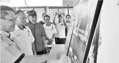  ??  ?? RASININ (dua kiri) menyaksika­n pameran foto sejarah di gerai pameran Jabatan Muzium Warisan Keningau. Turut kelihatan Yusop (tiga kiri) dan Pegawai Jabatan Muzium Warisan Keningau Doutis Goukit (kiri).