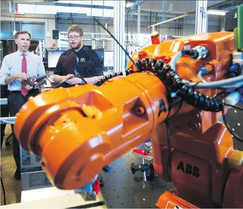  ?? TODD KOROL/THE CANADIAN PRESS FILES ?? Finance Minister Bill Morneau, left, operates a robot with a student during his tour of the robotics lab at the Southern Alberta Institute of Technology in Calgary last month. The Bank of Canada’s Carolyn Wilkins says technology has led to job...