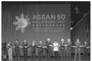  ?? AP/ANDREW HARNIK ?? U.S. President Donald Trump (center) and other leaders do the “ASEAN-way handshake” on stage during the opening ceremony at the ASEAN Summit at the Cultural Center of the Philippine­s on Monday in Manila, Philippine­s.