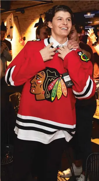  ?? BLACKHAWKS (ABOVE), AP ?? ABOVE: Lukas Reichel after being drafted by the Hawks in the first round. RIGHT: The Hawks’ Jonathan Toews and Berlin’s Maxim Lapierre face off during an exhibition game before last season in Germany.