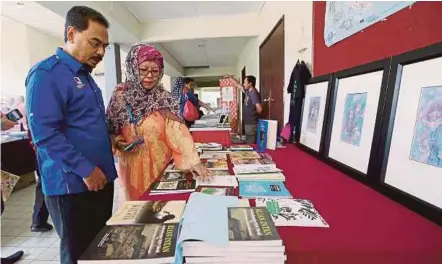  ??  ?? Novelist Professor Dr Siti Zainon Ismail (right) showing a collection of books an novels to state executive council member Datuk Dr Muhammad Amin Zakaria in Pangkor yesterday.