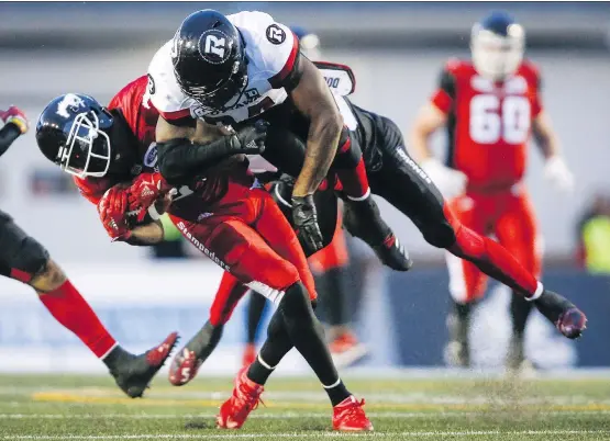  ?? JEFF MCINTOSH/THE CANADIAN PRESS ?? Ottawa Redblacks’ Kyries Hebert slams into the head of Calgary Stampeders’ DaVaris Daniels during Thursday’s CFL game in Calgary.