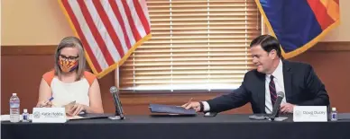  ?? ROSS D. FRANKLIN/POOL PHOTO ?? Secretary of State Katie Hobbs and Gov. Doug Ducey sign certificat­ion documents Monday.