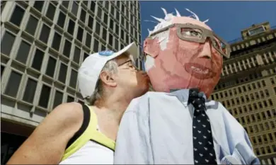  ?? ASSOCIATED PRESS — ALEX BRANDON ?? Sue Kirby poses for a picture with a larger-than-life Bernie Sanders, papier-mache head in Philadelph­ia Wednesday during the third day of the Democratic National Convention. Kirby, 65, built the doll about a year ago for Sanders rallies near home in...