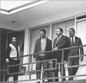  ?? Associated Press ?? THE REV. MARTIN LUTHER KING JR. stands with other civil rights leaders on the balcony of the Lorraine Motel in Memphis, Tenn., on April 3, 1968, the day before he was assassinat­ed.