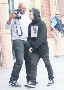  ?? | ZODIAC~SPLASH NEWS ?? Sean Penn’s son Hopper (right) and a photograph­er exchange words Tuesday outside a Beverly Hills, Calif., office building.