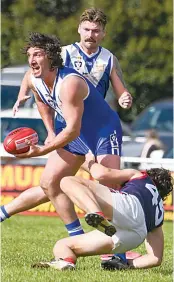  ?? ?? Thorpdale’s Anthony Rosato gets a handball away despite the tackle of Marcus Twomey.