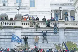  ?? [JOSE LUIS MAGANA/AP PHOTO] ?? Supporters of President Donald Trump climb the west wall of the U.S. Capitol on Wednesday in Washington.