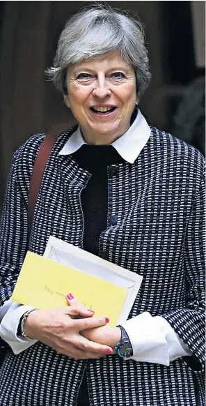  ??  ?? Theresa May leaves church yesterday, carrying what were thought to be birthday cards. She was 61 last week