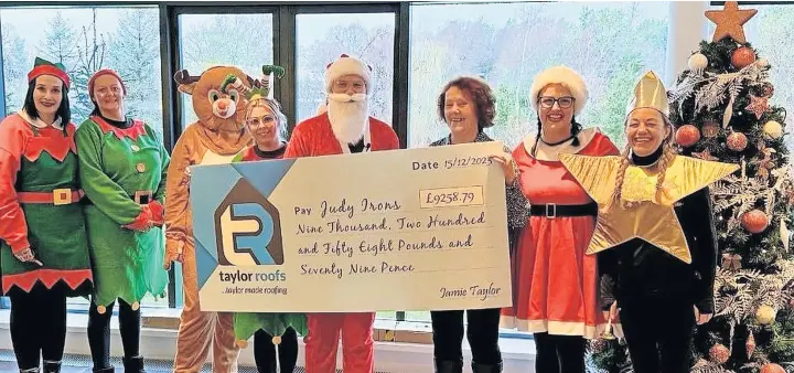  ?? ?? Delighted Judy Irons collects hers prize from the team at Taylor Roofs