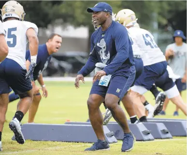  ?? TOMMY GILLIGAN / AP ?? Navy cornerback­s coach Robert Green encourages players as they run a drill during practice. Green spent the past two seasons as a defensive assistant for the Midshipmen after also serving as cornerback­s coach in 2018.