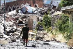  ?? AHMAD AL-BASHA/AFP ?? A Yemeni man inspects the damage on a street following clashes between pro-government militants and Shiite Huthi rebels on Tuesday.