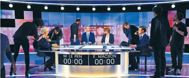  ??  ?? Marine Le Pen and Emmanuel Macron have their make-up applied before the heated live debate last night