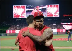  ?? AP Photo/Marcio Jose Sanchez ?? ■ Los Angeles Angels relief pitcher Felix Pena, right, hugs starter Taylor Cole after they threw a combined-no hitter against the Seattle Mariners on Friday in Anaheim, Calif. The Angels won, 13-0.