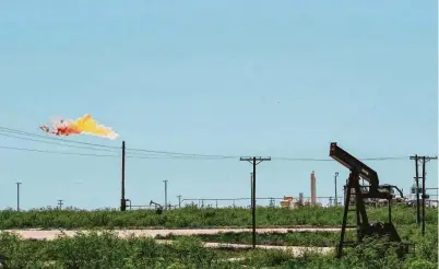  ?? Paul Ratje / AFP via Getty Images ?? A flare stack operates next to pump jacks and other oil and gas infrastruc­ture in Odessa. Shale companies took on debt to finance operations and can only make ends meet at about $40 a barrel.