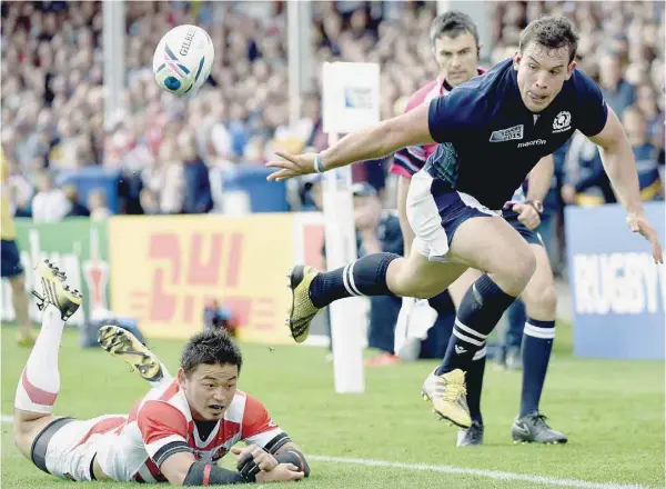  ?? — AFP ?? Scotland’s John Hardie (right) passes the ball backwards as he sets up his try during a Pool B match of the 2015 Rugby World Cup against Japan at Kingsholm Stadium in Gloucester, west England.