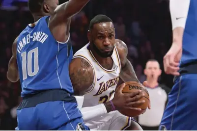  ?? AP ?? SINAGASA ni Los Angeles star guard LeBron James ang depensa ni Dallas Mavericks forward Dorian Finney-Smith sa maaksiyong tagpo ng kanilang laro sa NBA.