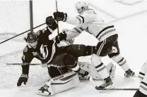  ?? Jason Franson / Associated Press ?? The Stars’ Miro Heiskanen checks the Lightning’s Brayden Point on top of Stars goalie Anton Khudobin during Game 2.