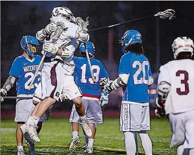  ?? SARAH GORDON/THE DAY ?? East Lyme’s Larry Nolan, left, jumps into the arms of Matthew Boguszewsk­i to celebrate a goal during the Vikings’ 11-9 win over Waterford on Thursday night in the ECC boys’ lacrosse tournament title game at East Lyme.