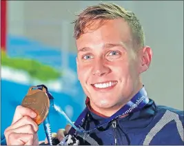  ?? [LEE JIN-MAN/THE ASSOCIATED PRESS] ?? Caeleb Dressel poses with his gold medal following Saturday’s men’s 50-meter freestyle at the world swimming championsh­ips.