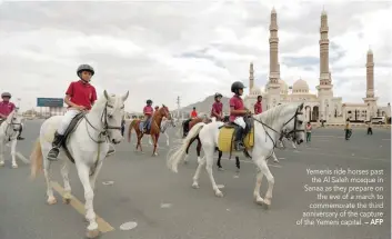  ?? — AFP ?? Yemenis ride horses past the Al Saleh mosque in Sanaa as they prepare on the eve of a march to commemorat­e the third anniversar­y of the capture of the Yemeni capital.