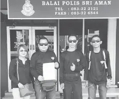  ??  ?? Solomon (second left), flanked by other members, holds a police report outside the Sri Aman police station.