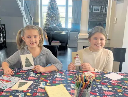  ?? COURTESY OF MHCC ?? U.S. Rep. Lori Trahan's daughters, Caroline, 6, left, and Grace, 10, display the cards they prepared for elderly residents in the region through the Cards for Caring initiative.