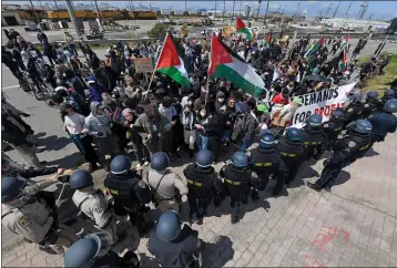  ?? JOSE CARLOS FAJARDO — STAFF PHOTOGRAPH­ER ?? CHP officers struggle but manage to push protesters opposed to the war in Gaza off southbound Interstate 880, which allowed traffic to pass in Oakland on Monday. Demonstrat­ors arrived around 7a.m. to block the freeway.