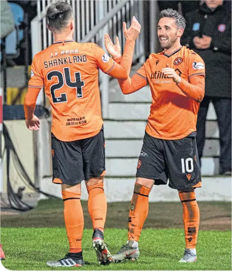  ??  ?? Strike partners Nicky Clark and Lawrence Shankland congratula­te each other on their way to a comfortabl­e win over their city rivals at Dens Park on Friday night