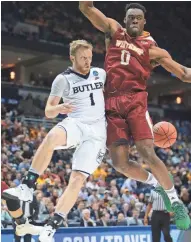  ?? MARK HOFFMAN / MILWAUKEE JOURNAL SENTINEL ?? Butler guard Tyler Lewis passes behind the back of Winthrop center Duby Okeke during their first-round NCAA game.