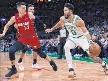  ?? Charles Krupa The Associated Press ?? Celtics forward Jayson Tatum drives to the basket against Heat guard Tyler Herro during Boston’s 134-121 win Wednesday at TD Garden. Tatum scored 49 points.