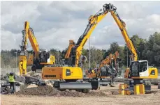  ??  ?? Mitarbeite­r von Liebherr führten einzelne Baumaschin­en vor, so wie hier bei einer simulierte­n Kanal-Baustelle.