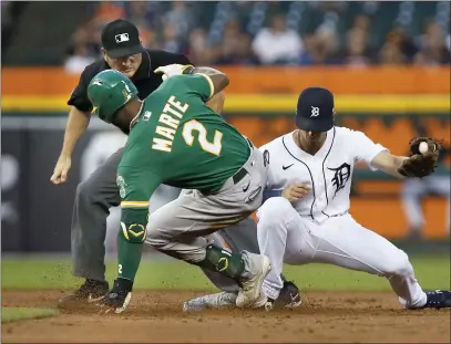  ?? PHOTOS BY DUANE BURLESON — THE ASSOCIATED PRESS ?? The A’s Starling Marte (2) beats the tag from Detroit Tigers shortstop Zack Short for a double, with umpire Sean Barber covering second base, during the third inning on Tuesday in Detroit.