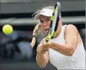  ?? BEN CURTIS/AP ?? Second-seeded Caroline Wozniacki returns a shot against Ekaterina Makarova but will not return for the next round.