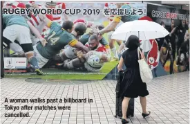  ??  ?? A woman walks past a billboard in Tokyo after matches were cancelled.